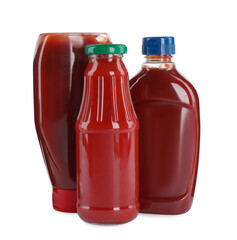 Different bottles of ketchup on white background