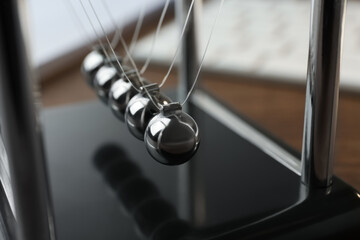 Newton's cradle on table, closeup. Physics law of energy conservation