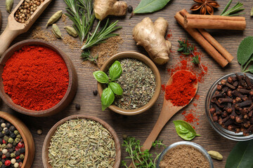 Different herbs and spices on wooden table, flat lay