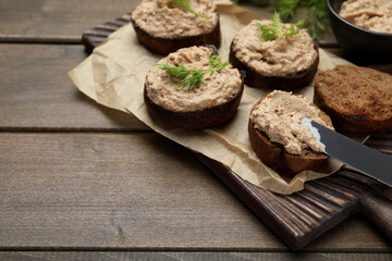 Slices of bread with delicious pate on wooden table, space for text