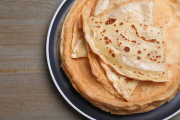 Stack of delicious crepes on grey wooden table, top view