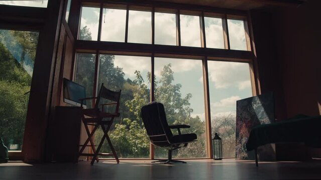 A five-hour time-lapse shot from a minimalist studio with a large window to nature and the sky where clouds drift by and the sun shines through