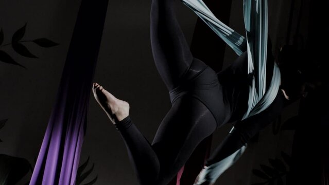 Woman in aerial dance with hanging color fabrics