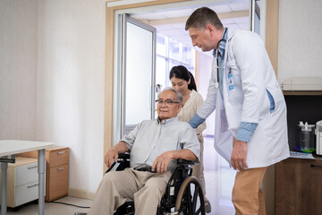 Doctor talk with a patient at hospital. Old man with wheelchair. Health and wellness.