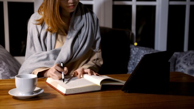 Asian woman reading book and research at the night at home.