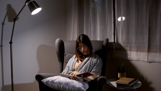 Asian Woman Reading Book And Research At The Night At Home.