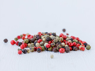 Black, red, green, white dried peppercorns background or texture. Handful of spice. Mix of four different peppers. Selective focus. Food backgrond, full frame, close up, copy space