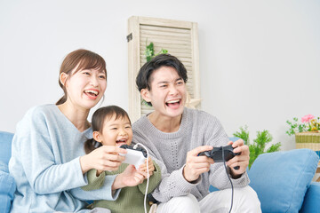 両親と娘　テレビゲームで遊ぶ　リビング