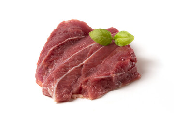 A fresh piece of pork or beef with streaks of bacon and basil leaf on a white background. Raw meat for cooking.