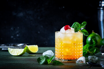 Mai Tai popular alcoholic cocktail with rum, liqueur, syrup, lime juice, mint and crushed ice. Dark...