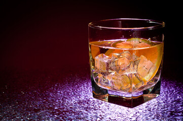 Glass transparent glass with drink and ice cubes for cooling and lemon.