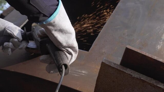 metal grinding job is being done by a fabricator in a factory 