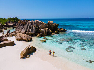 Anse Cocos La Digue Seychelles, a young couple of men and women on a tropical beach during a luxury...