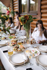 Family celebrating at dinner on summer terrace. Hands while toasting with glasses of wine. Happy people at terrace party