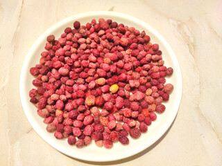 Berry like fruit  - Kafal, the state fruit of Uttarakhand on a white plate on a light background.