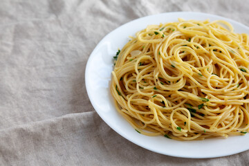 Homemade Spaghetti with Garlic and Oil Pasta on a Plate, side view. Copy space.