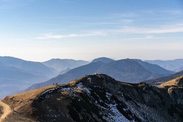 Mountain chain and hills under light blue sky