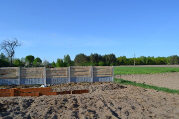 Fototapeta na wymiar beds on the site and a wooden fence behind them in country style