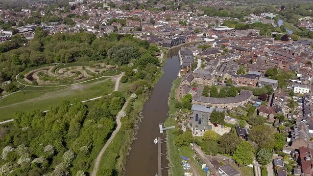 Aerial footage along the River Ouse as it enters the town of Lewes in East Sussex in Southern England.