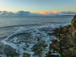 Aerial sunrise seascape with sea foam and low cloud bank