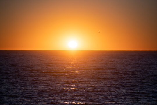 Golden sunrise sunset over the sea waves. Calm ocean water.