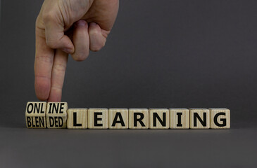 Blended or online learning symbol. Businessman turns cubes changes words blended learning to online...