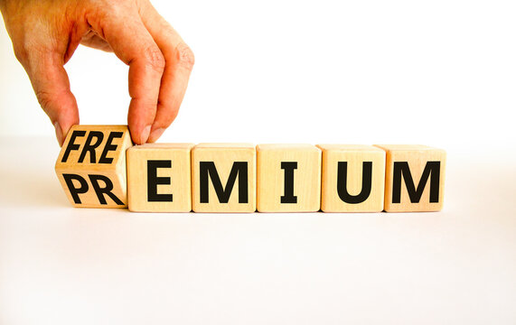 Premium or freemium symbol. Businessman turns wooden cubes and changes the concept word Premium to Freemium. Beautiful white table white background. Business premium or freemium concept. Copy space.