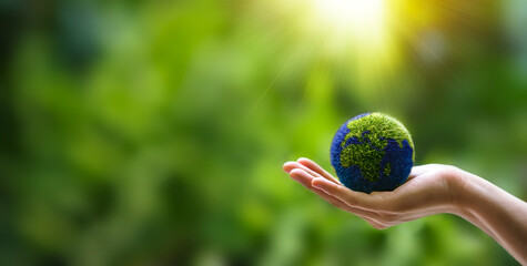 Hands holding globe on green nature forest background in saving environment concept, save clean...