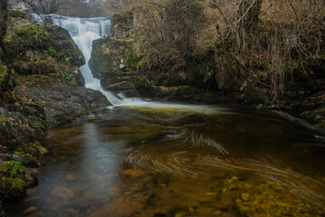 Stunning vibrant landscape image of Aira Force Upper Falls in Lake District during colorful Autumn showing