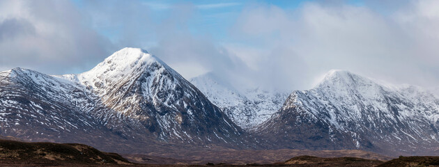Majestic Winter panorama landscape image of mountain range and peaks viewed from Loch Ba in...