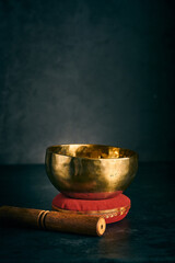 tibetan bowl on a red cushion in a dark background