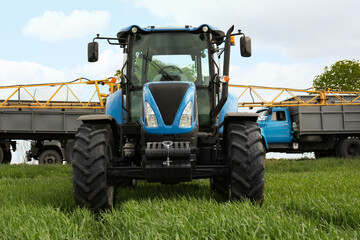 Fototapeta premium Modern tractor and truck in field on sunny day. Agricultural industry