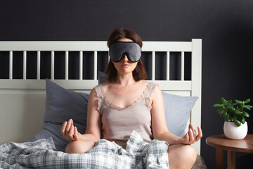 Woman meditating in the bedroom, relaxing before sleeping, mental health concept - 504715935