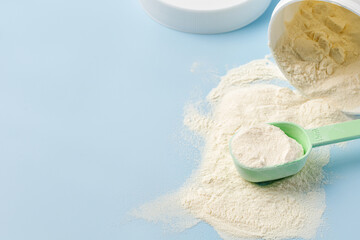 Сollagen powder in measure spoon near jar on blue background. Trendy supplement for skin care