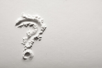 Question mark on powder background in black and white.