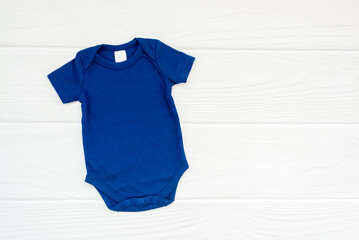 Blank blue baby bodysuit flatlay mockup on white wood background, copyspace, top view. - obrazy, fototapety, plakaty