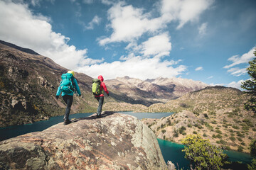 Two women backpackers hiking  in beautiful winter mountains - obrazy, fototapety, plakaty