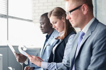 Smiling businesswoman looking at camera at seminar with her colleagues near by