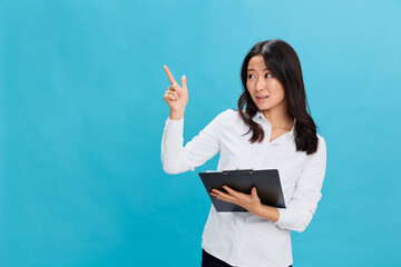Excited cute Asian businesswoman in classic office dress code holds folder tablet with resume point...