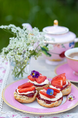 Obraz na płótnie Canvas Freshly baked scones with tea served in the garden