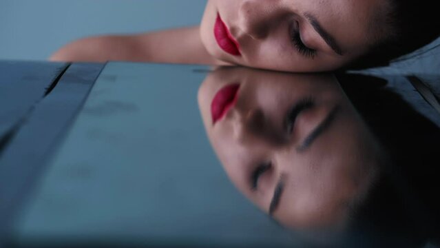 Beauty care. Facial treatment. Skin dermatology. Creative fashion portrait of attractive young woman face with red lips in mirror reflection.