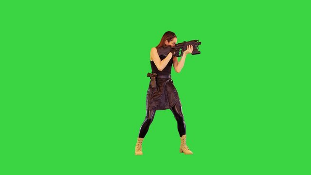 Game-character girl with a gun takes an aim and starts shooting on a Green Screen, Chroma Key.