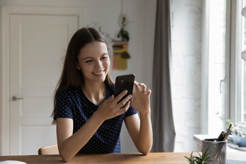 Happy millennial gen Z smartphone user chatting online, using virtual multimedia app on mobile phone, texting message, browsing Internet, watching content, making video call. Communication concept
