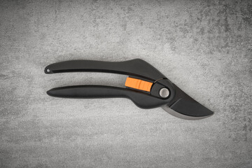 Garden secateurs on concrete gray background. Top view.
