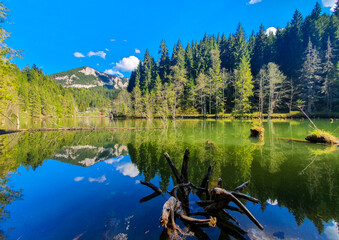 a beautiful landscape with mountains and trees reflected in the water at Red Lake - Romania