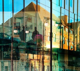 city street vitrines  reflection on buildings windows glass people walking sunset beam urban lifestyle  town scene 