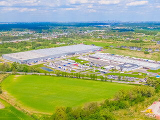 Aerial view of goods warehouse. Logistics center in industrial city zone from above. Aerial view of trucks loading at logistic center