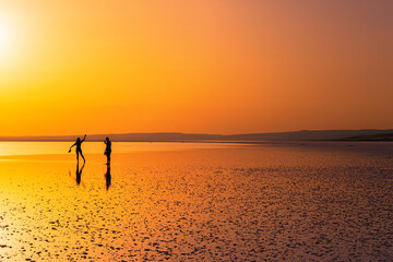 silhouette of man posing on salt lake at sunset © emrah