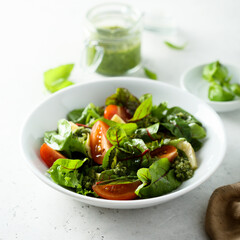 Healthy green salad with tomatoes and pesto