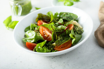 Healthy green salad with tomatoes and pesto